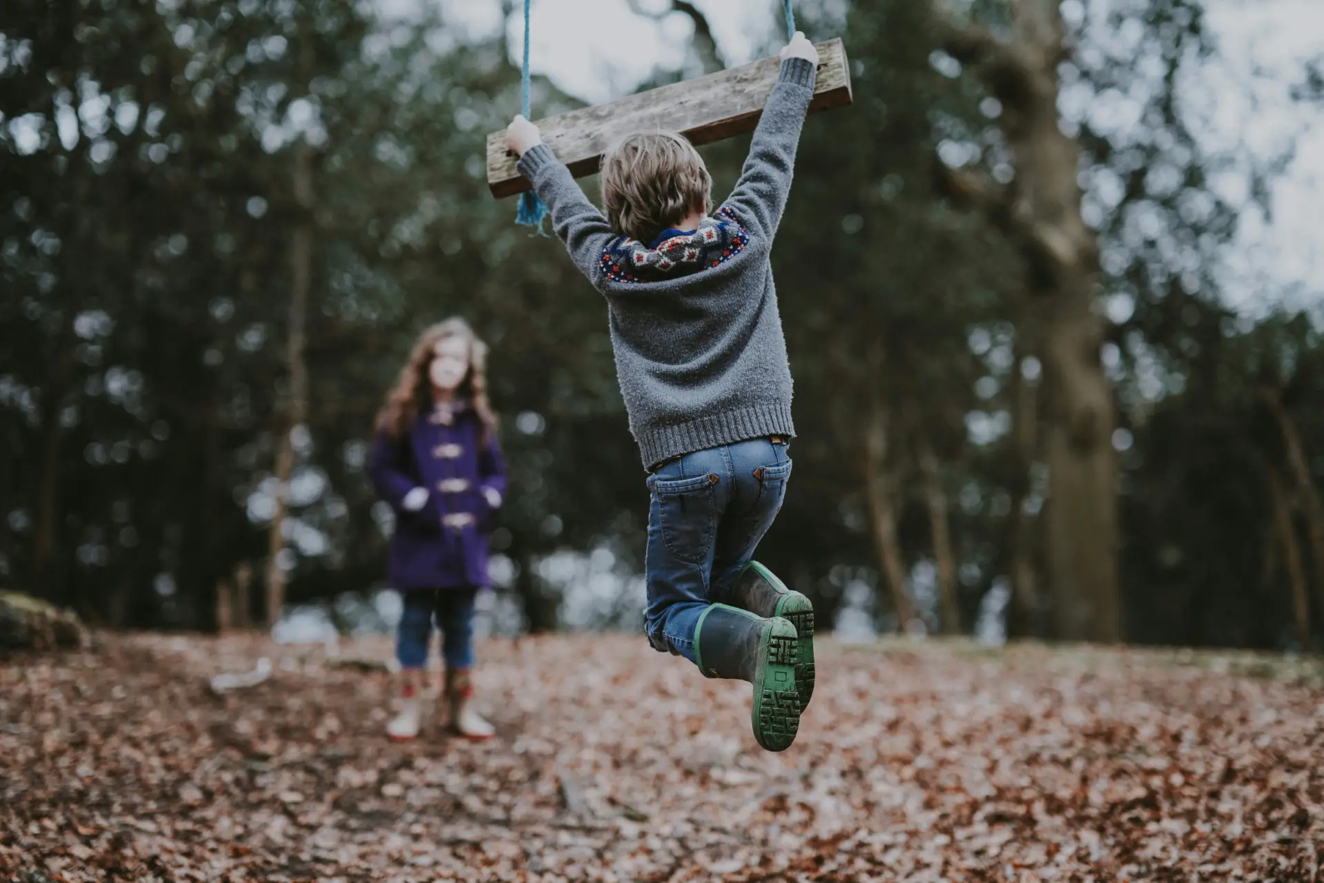 Two young children playing in a forest Two young children playing in a forest